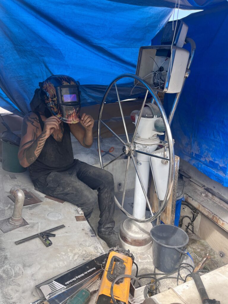 Tom mit Schweißhelm beim Arbeiten am Segelboot