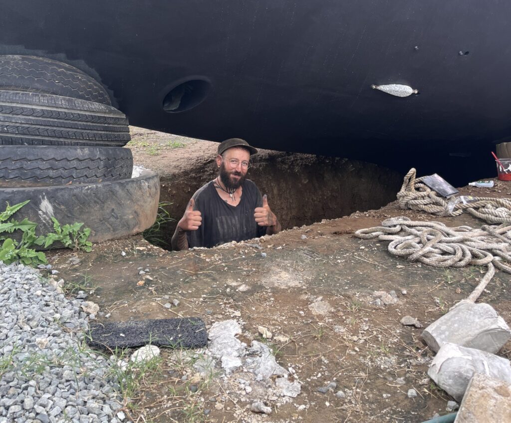 Tom im Pit der Vuda Marina, über ihm sein Segelboot Lola