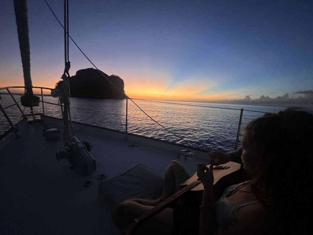 Theresa spielt Gitarre an Deck unseres Segelbootes Lola.